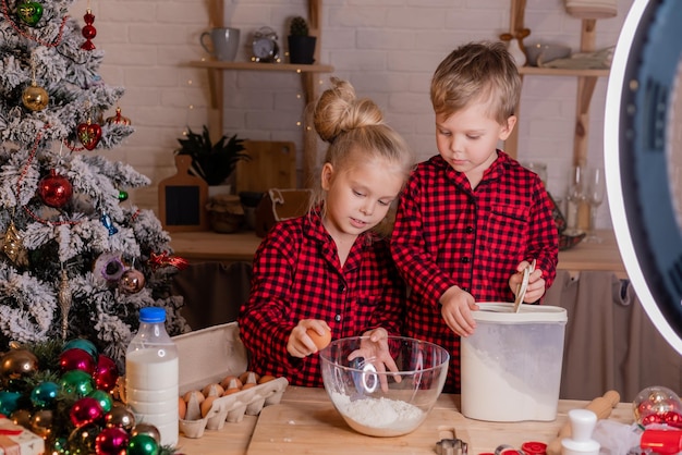 Glückliche Kinder backen zu Hause in der Küche Weihnachtsplätzchen