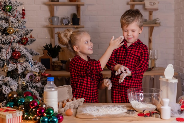 Glückliche Kinder backen zu Hause in der Küche Weihnachtsplätzchen