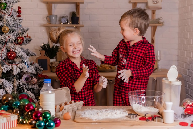 Glückliche Kinder backen zu Hause in der Küche Weihnachtsplätzchen