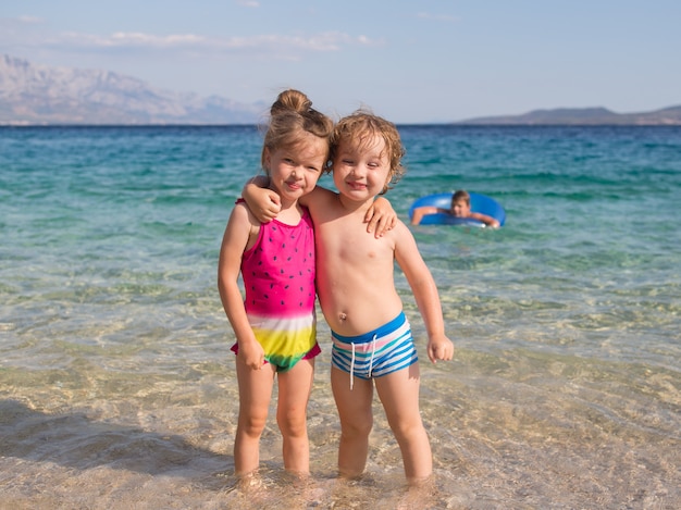 glückliche Kinder, Bruder und Schwester, am Strand umarmend, Kroatien, Adria