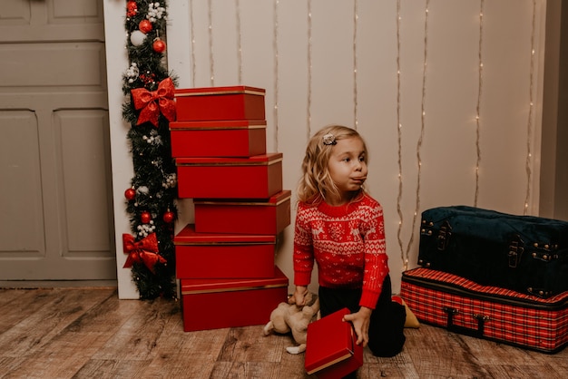 Glückliche Kinder, die am geschmückten Weihnachtsbaum und den Girlanden Silvester und Weihnachten feiern