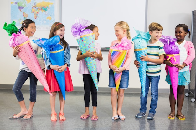 Glückliche Kinder, die Geschenke im Klassenzimmer halten