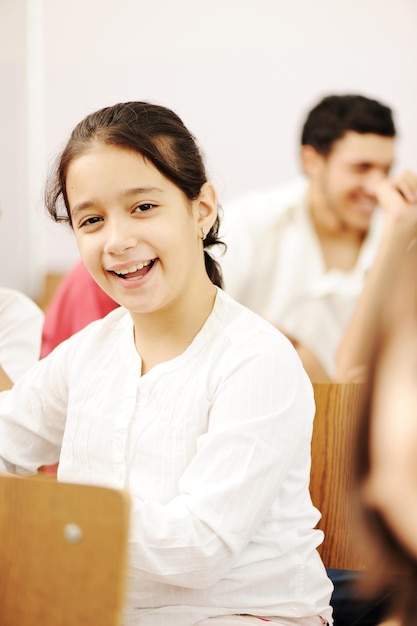 Glückliche Kinder, die im Klassenzimmer lächeln und lachen