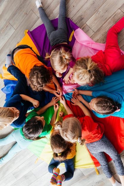 Foto glückliche kinder, die im kreis auf einem boden liegen