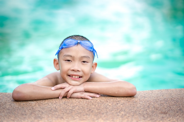 Glückliche Kinder, die im Swimmingpool spielen und schwimmen