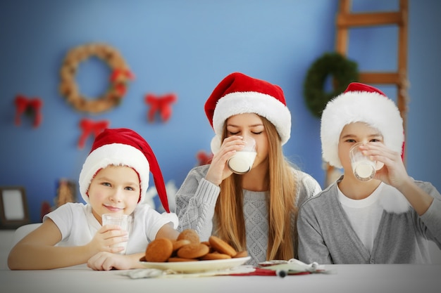 Glückliche Kinder essen im dekorierten Weihnachtsraum Christmas