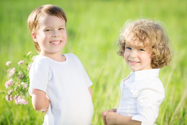 Glückliche Kinder mit Blumen im Frühlingsfeld