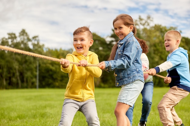 glückliche Kinder spielen Tugofwar im Park