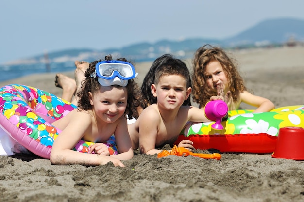 glückliche kindergruppe hat spaß am strand, während sie mit spielzeug spielen, das springt