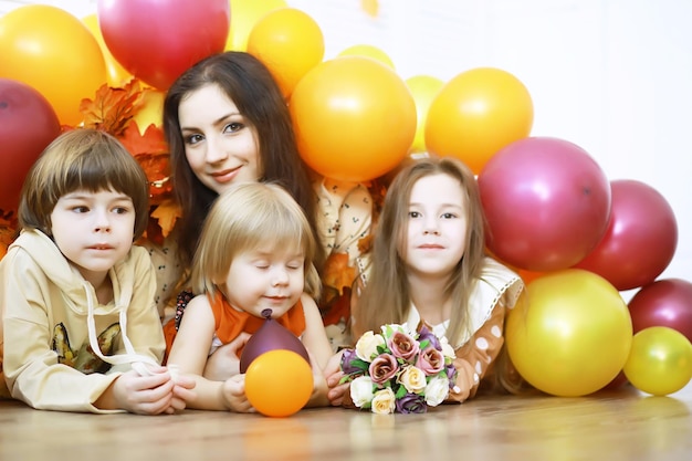 Glückliche Kindergruppe hat Spaß und spielt mit dem Lehrer im Kindergarten-Indoor-Vorschulbildungskonzept