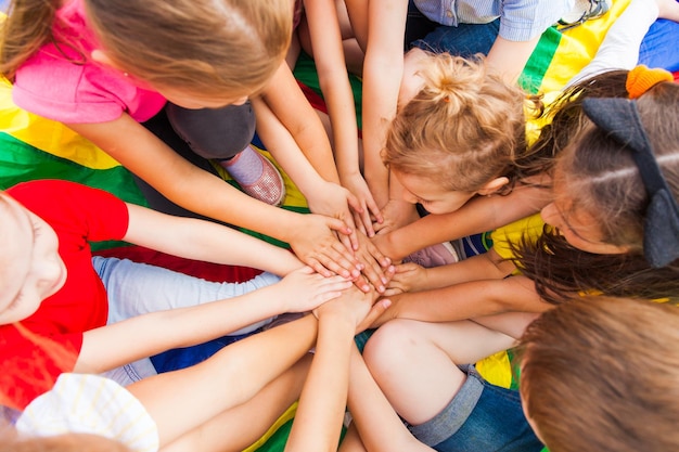 Glückliche Kindermitglieder einer großen Familie, die Zeit zusammen verbringen. Brüder und Schwestern, die bei einem Familientreffen einen Kreis ihrer Hände bilden. Glückliches Familienkonzept