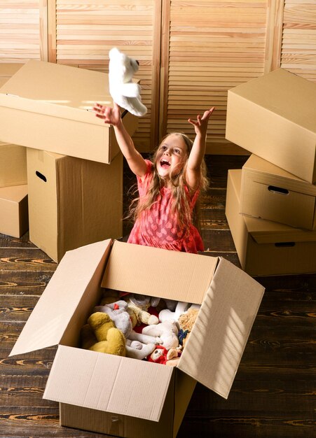 Glückliche Kindheit Familie umziehen stressig für Kinder Box-Paket und Lagerung Kleines Kind bereiten Spielzeug für den Umzug vor Kid Girl Umzugskartons Hintergrund Umzugskonzept Lieferservice