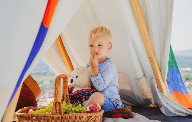 Glückliche Kindheit Kind im Zelt Junge spielt im Freien Kindercamping Spaß im Freien Campingplatz