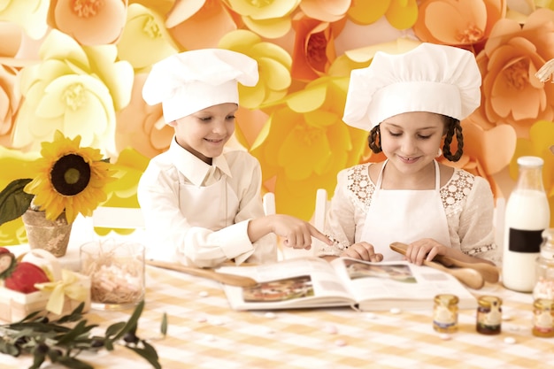glückliche kleine Kinder in Form eines Kochs, um ein leckeres zu kochen