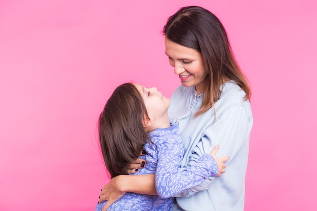 glückliche kleine Tochter, die ihre Mutter umarmt