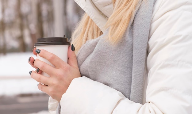 Glückliche lächelnde erwachsene touristische Frau, die Papierkaffeetasse hält