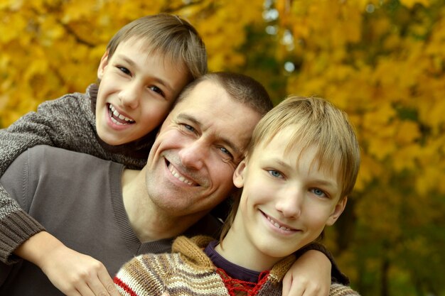 Glückliche lächelnde Familie, die im Herbstpark sich entspannt