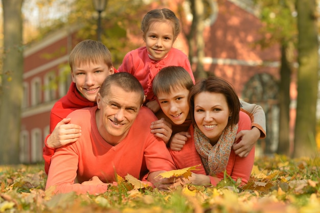 Glückliche lächelnde Familie, die im Herbstpark sich entspannt