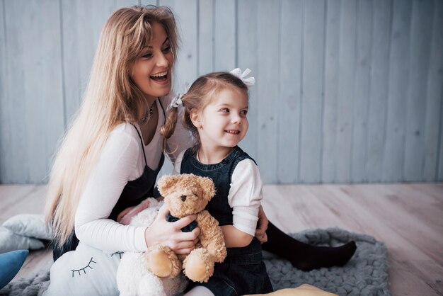 Glückliche liebevolle Familie. Bemuttern Sie und ihr Tochterkindermädchen, das spielt und umarmt