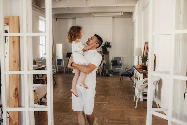 Glückliche liebevolle Familie. Ein Vater und seine Tochter, ein kleines Mädchen, spielen zusammen. Konzept zum Vatertag.