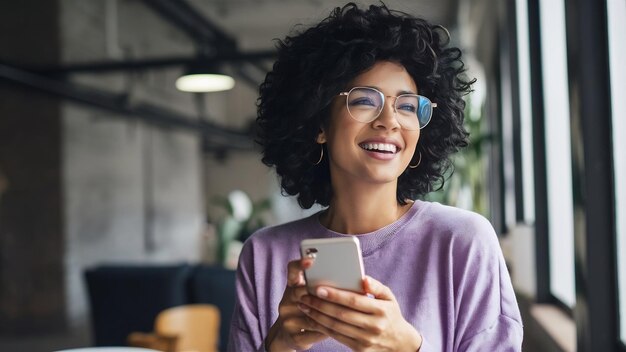 Glückliche lockerhaarige Frau hält moderne Mobiltelefon-Chats online lächelt freudig trägt durchsichtige Gl