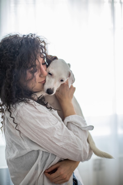 Glückliche lockige brünette Frau Haustierbesitzerin hält Hund Jack Russell Terrier Rasse Gefühl Liebe Freundschaft