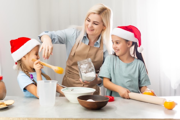 glückliche lustige mutter und kinder backen weihnachtsplätzchen