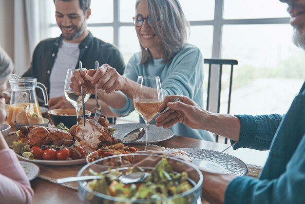 Glückliche Mehrgenerationenfamilie, die Händchen hält und vor dem Abendessen betet