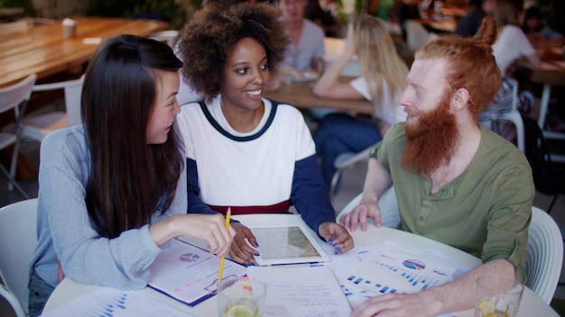 Foto glückliche millennial-freunde arbeiten in einem modernen café zusammen