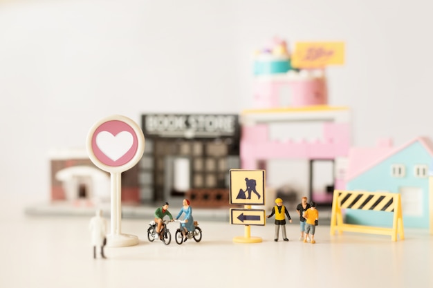 Glückliche Miniatur der jungen Paare auf Fahrradfahrt (Miniatur) auf Fahrradfahrt in der Stadt Valentinstag mit selektivem Fokus und weicher Pastellfarbe getont.