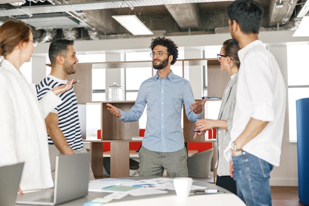 Glückliche Mitarbeiter, die beim Teamwork-Konzept für Bürotreffen zusammenarbeiten und zusammenarbeiten