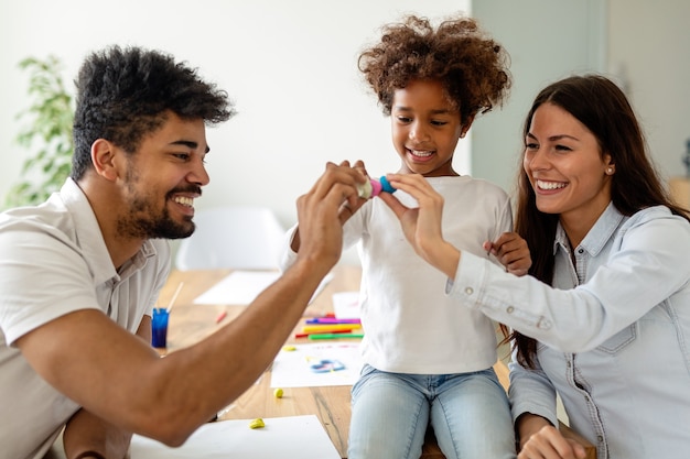 Glückliche multiethnische Familie, die Zeit zusammen zu Hause verbringt. Menschenbildungsspaß-Glückskonzept