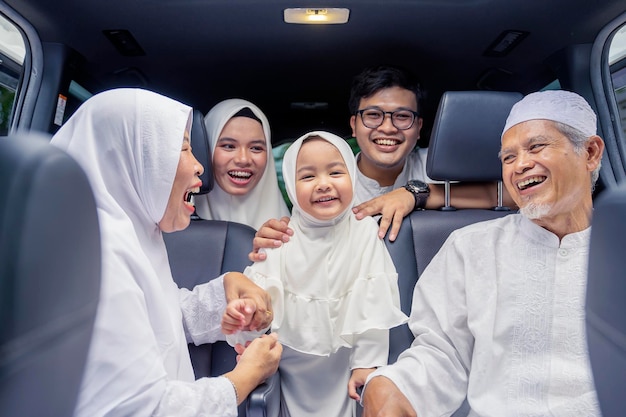 Glückliche muslimische Familie mit drei Generationen in einem Auto
