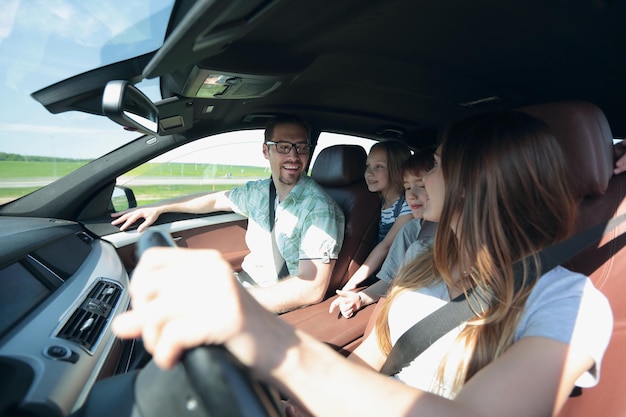 Glückliche Mutter, die ein Familienauto fährt, das Konzept der Freiheit und des Reisens