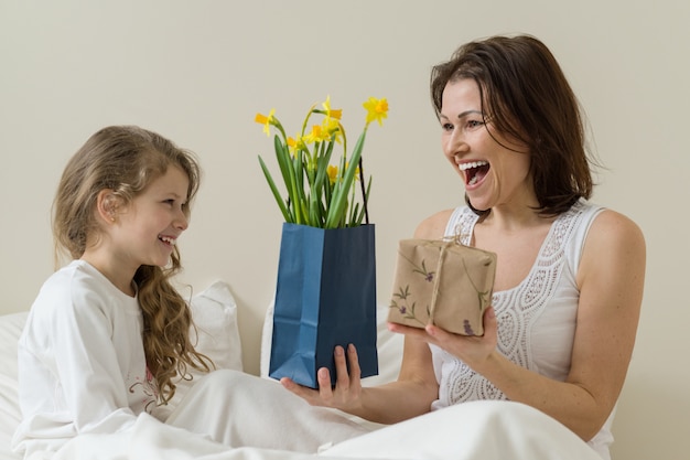 Glückliche Mutter erhielt Blumenstrauß und Geschenk von ihrer kleinen Tochter