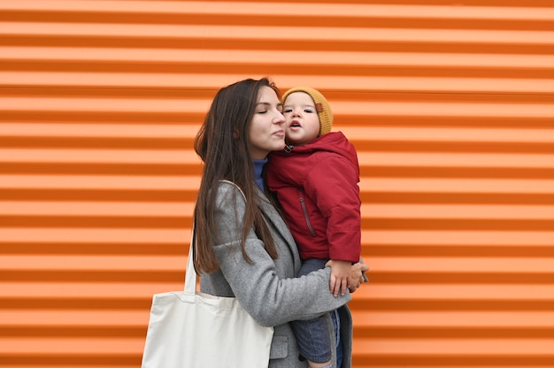 Glückliche Mutter mit Baby auf Orange