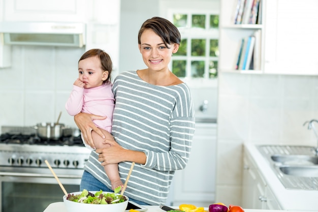 Glückliche Mutter mit Baby durch Küchenarbeitsplatte