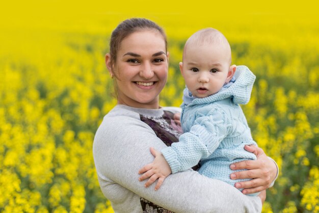 Glückliche Mutter mit dem Kind auf dem Feld