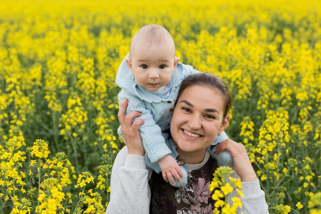 Glückliche Mutter mit dem Kind auf dem Feld