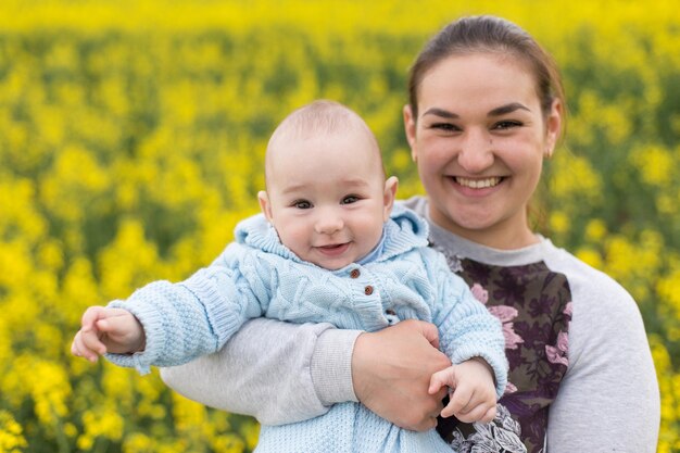 Glückliche Mutter mit dem Kind auf dem Feld