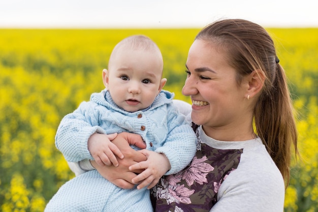 Glückliche Mutter mit dem Kind auf dem Feld