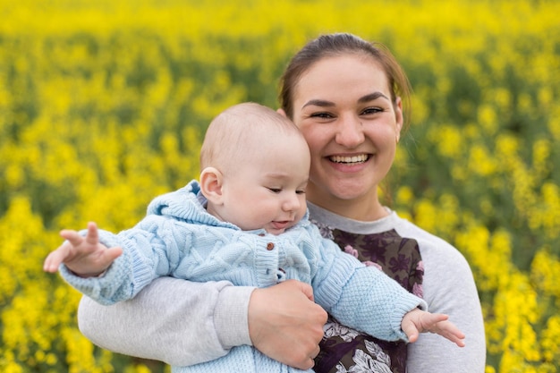 Glückliche Mutter mit dem Kind auf dem Feld