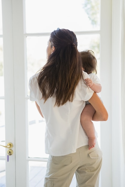 Glückliche Mutter mit ihrem niedlichen Baby schauen heraus