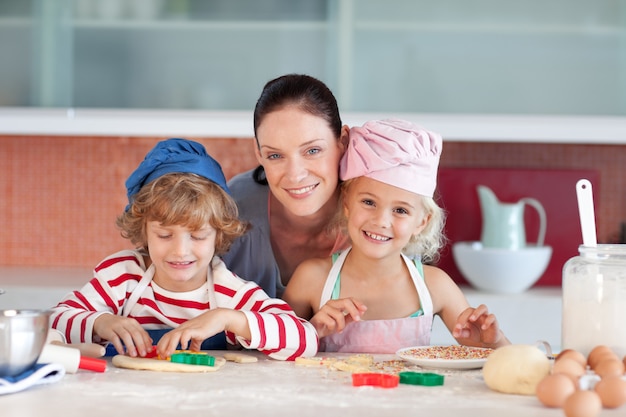 Glückliche Mutter mit ihren Kindern backen