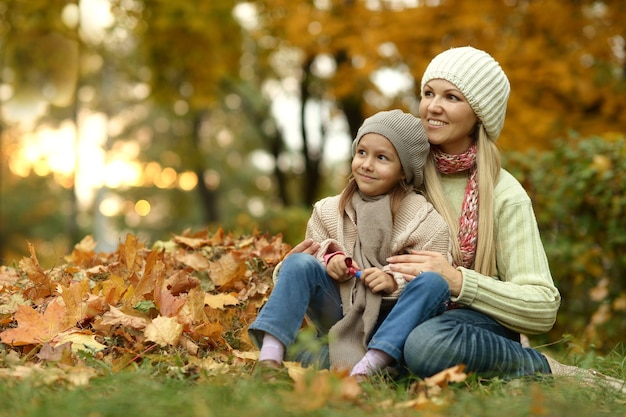 Glückliche Mutter mit ihrer süßen Tochter im Herbstpark