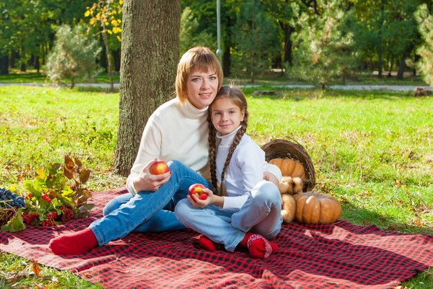 Glückliche Mutter mit kleiner Tochter im Herbstpark