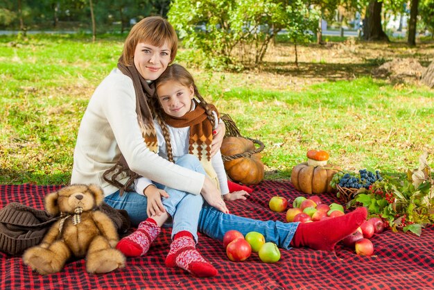 Glückliche Mutter mit kleiner Tochter im Herbstpark