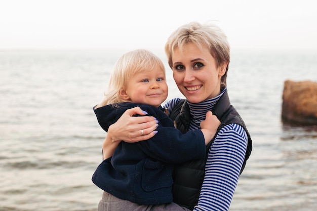 Glückliche Mutter mit Sohn an einem sonnigen Tag in der Nähe von Meer Erholung am Strand Eine glückliche Familie