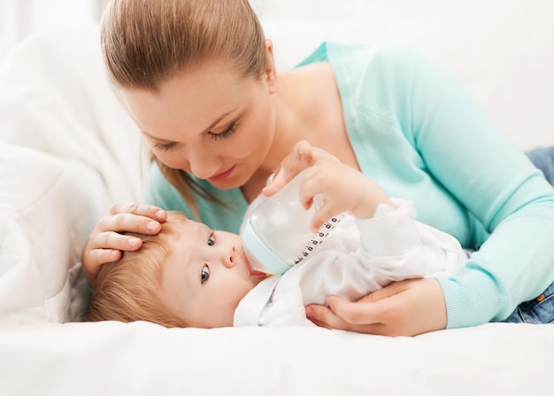 Glückliche mutter und entzückendes baby mit saugflasche