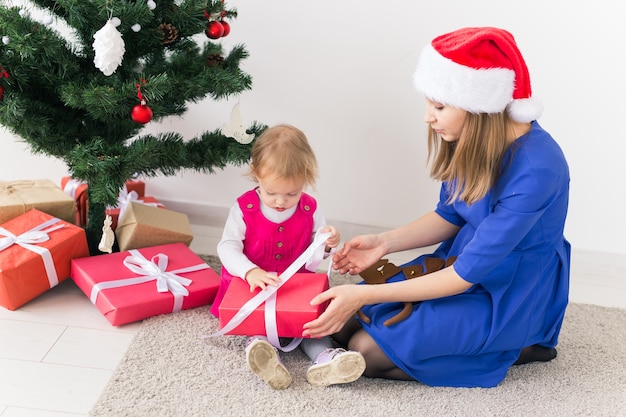 Glückliche Mutter und junges Mädchen, die Weihnachtsgeschenke öffnen